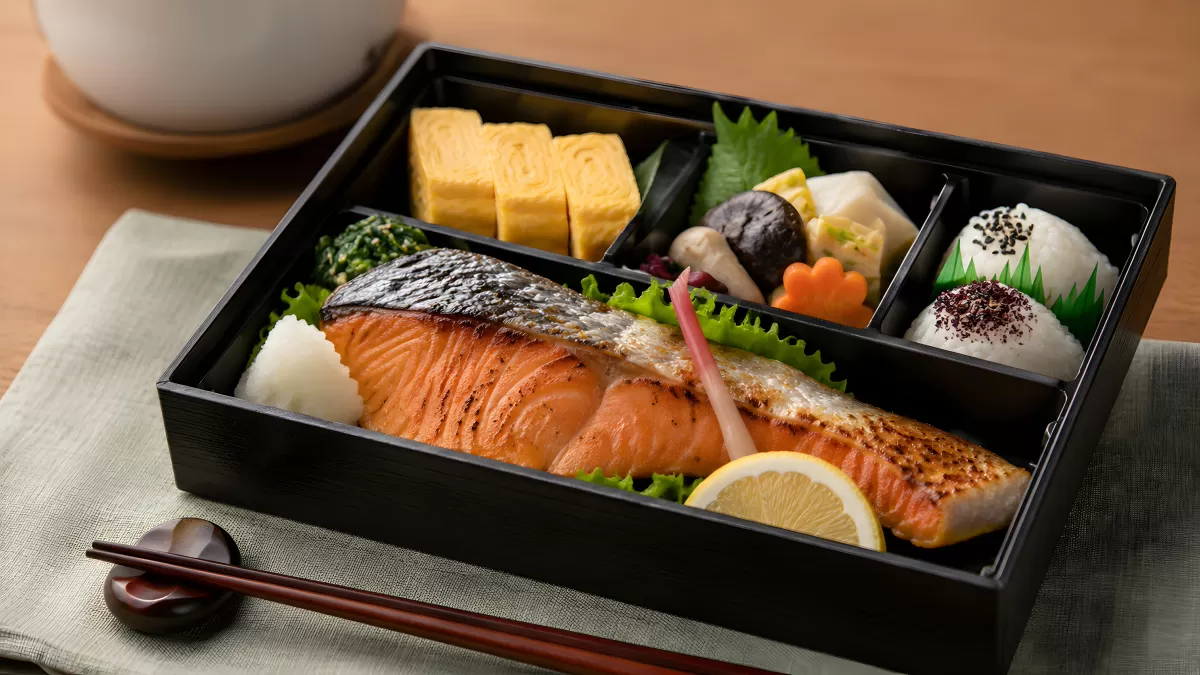 Japanische Bento-Box mit gegrilltem Lachs und Beilagen