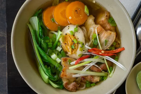 Japanische Ramen Nudelsuppe mit Bok Choy Gemüse, gekochtem Ei und Schweinefleisch Nahaufnahme