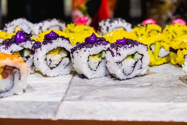 Japanisches Sushi in gelb und weiß mit lila Topping