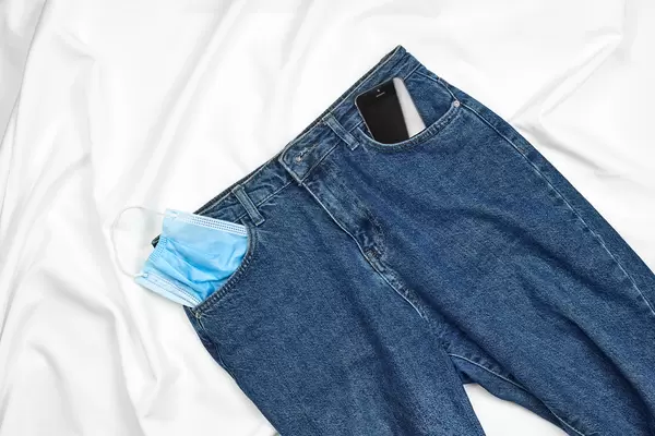 Jeans with a face mask and smartphone in the pocket