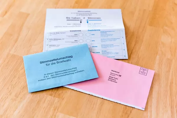 Jede Stimme zählt: Stimmzettel und Briefwahlunterlagen auf einem Holztisch