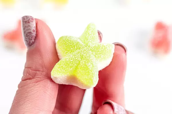 Jelly candy star in a woman's hand close up