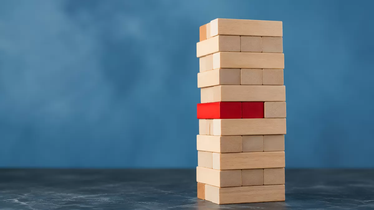 Jenga-Turm mit rotem Baustein als Risiko-Symbol