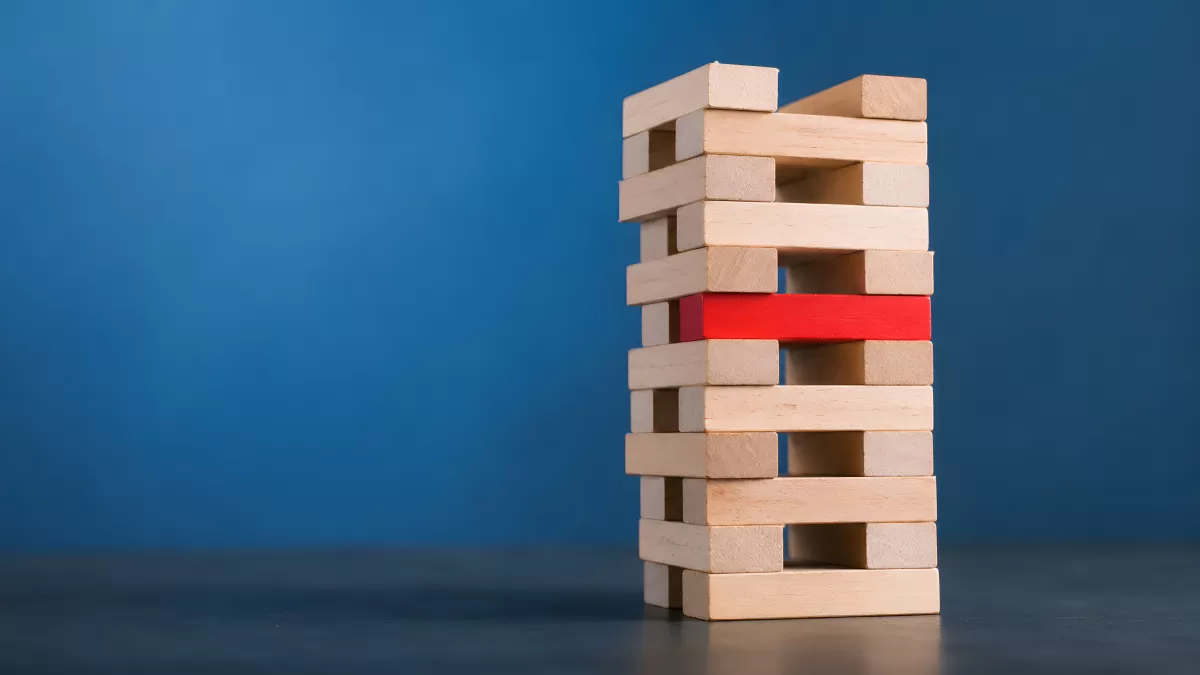 Jenga-Turm mit rotem Baustein als Schwachpunkt