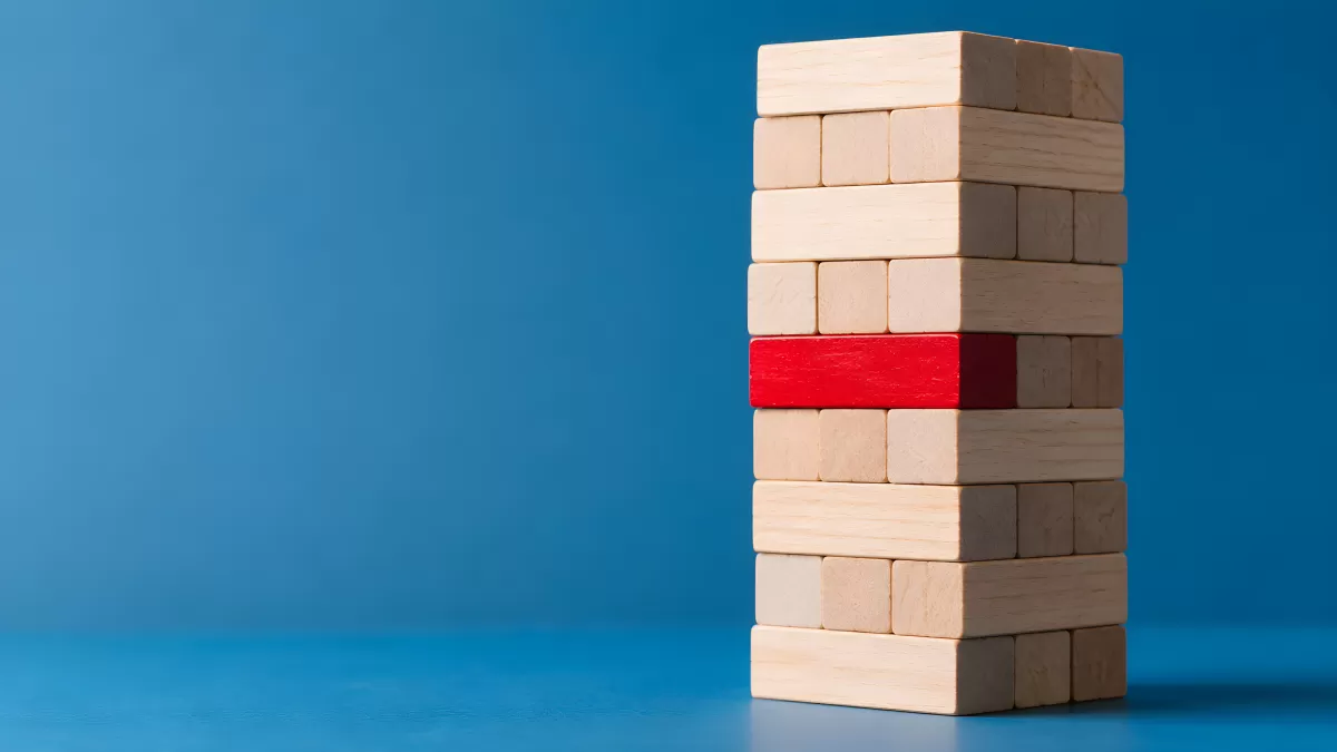 Jenga-Turm mit rotem Holzblock als Risikosymbol