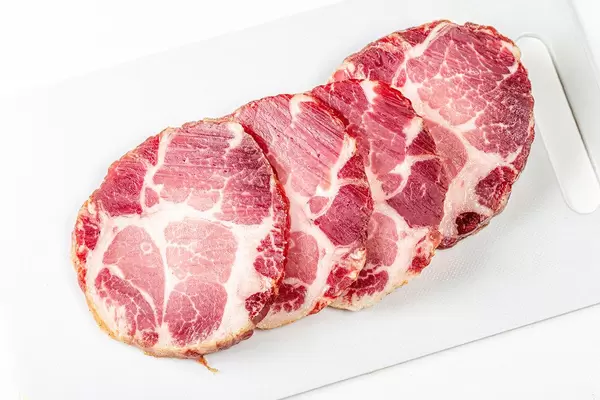 Jerky pork meat on a white kitchen board (Flip 2020)