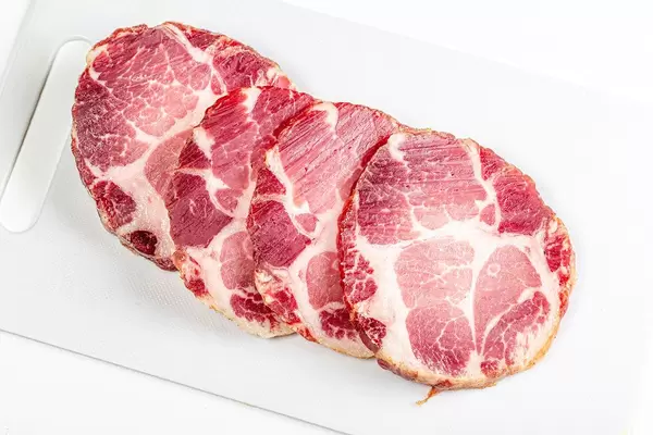 Jerky pork meat on a white kitchen board