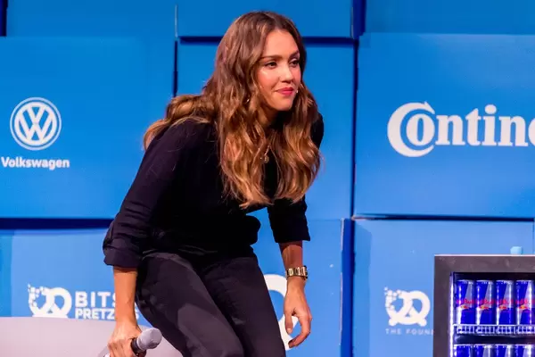 Jessica Alba setzt sich auf der Bits & Pretzels Bühne auf das Sofa