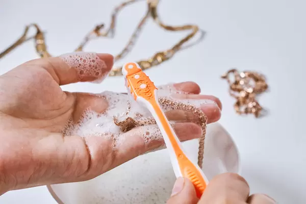 Jeweller hand cleaning and polishing vintage jewelry