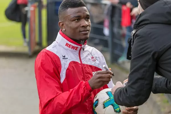 Jhon Córdoba signiert einen Ball