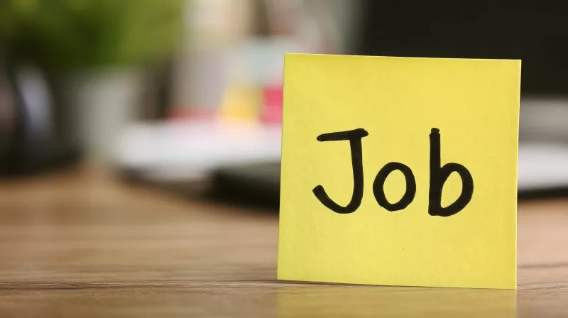 Jobanzeige auf gelbem Notizzettel im Büro