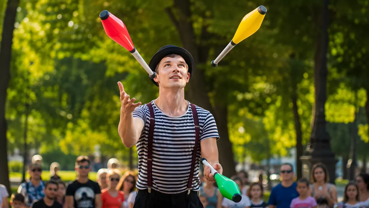 Jongleur im Park begeistert Publikum mit bunten Keulen