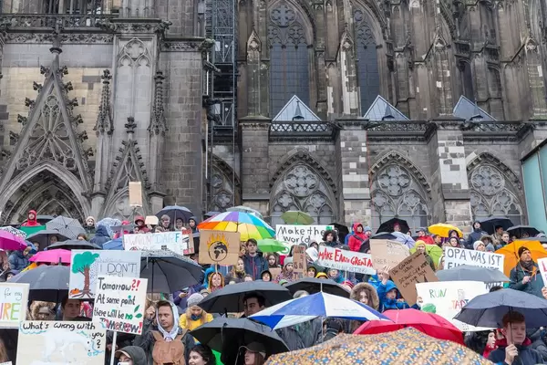 Jugendliche mit bunten Schilden für Umweltschutz vor dem Kölner Dom