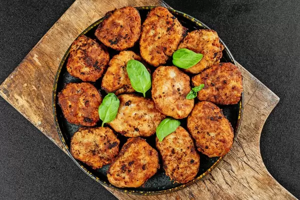 Juicy delicious meat cutlets on a old wooden kitchen board, top view