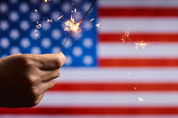 June 14 - US Flag Day. Celebration of American national holiday with sparklers against the American flag
