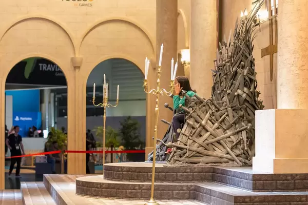 Junge Besucherin sitzt auf dem Eisernen Thron auf der Gamescom