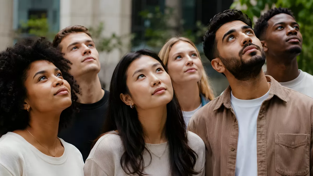 Junge diverse Gruppe blickt gemeinsam nach oben