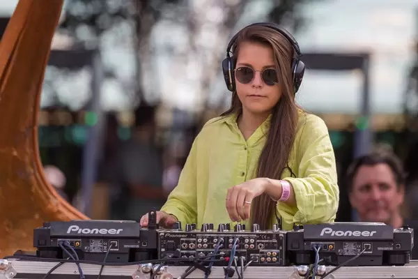 Junge DJane Kopfhörern am Mischpult legt am Tomorrowland Festival 2019 auf