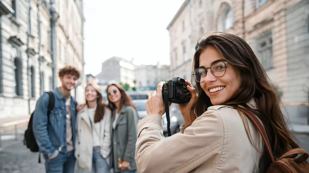 Junge Frau fotografiert Freunde auf Stadtstraße