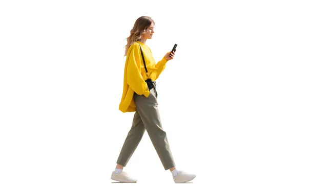 Junge Frau in gelbem Pullover mit Smartphone