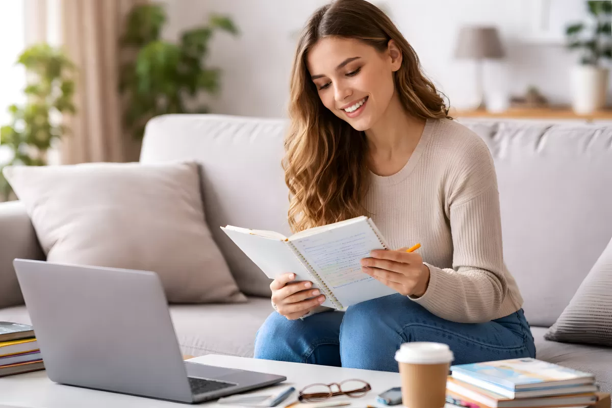 Junge Frau lernt zu Hause mit Notizbuch und Laptop