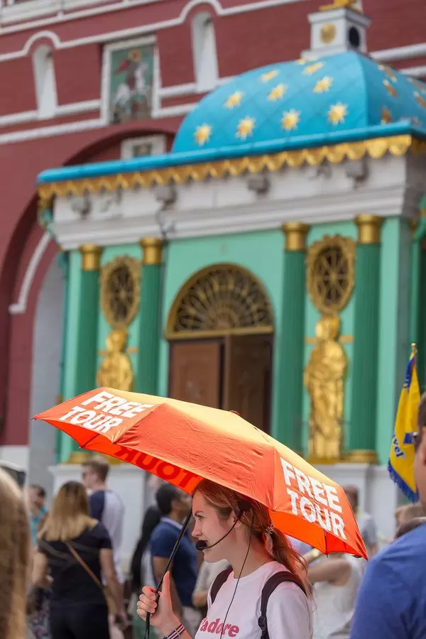 Junge Frau mit einem Regenschirm in der Hand mit der Aufschrift Free Tour