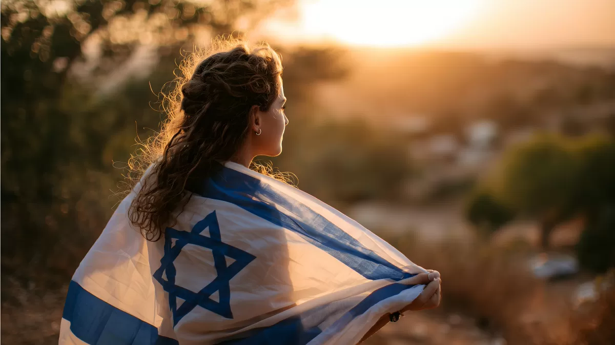 Junge Frau mit israelischer Flagge bei Sonnenuntergang