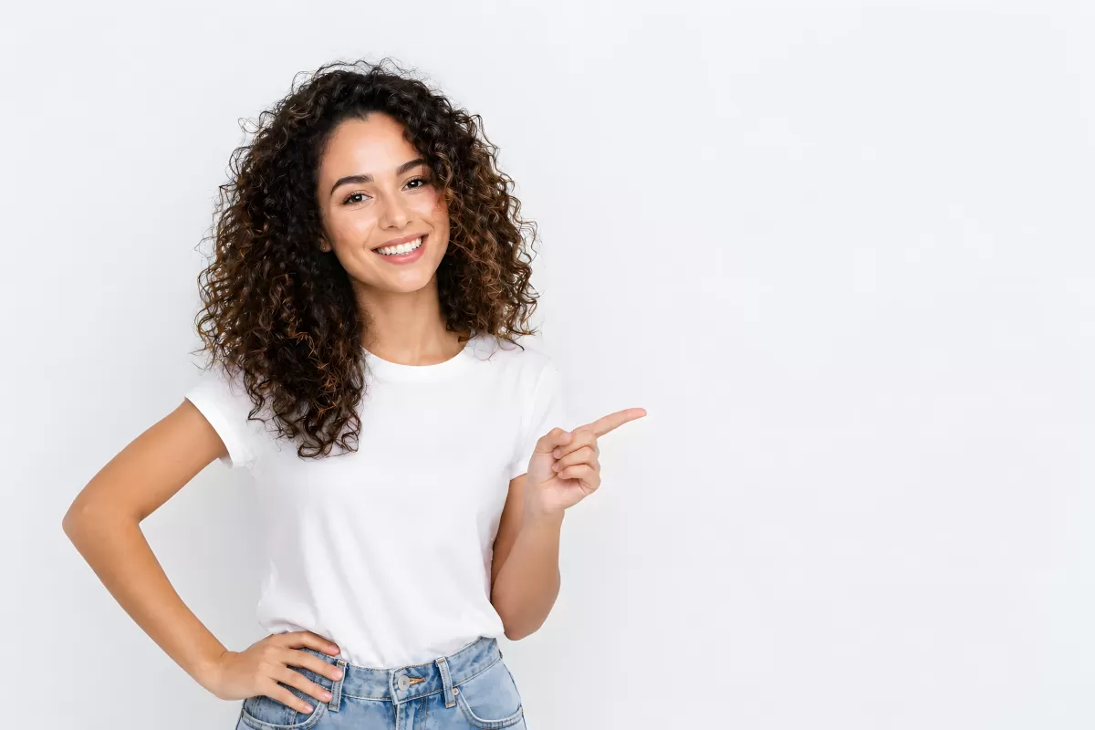 Junge Frau mit lockigem Haar zeigt seitlich