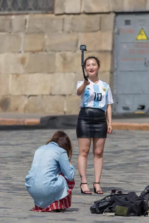 Junge Frau mit Maradona-Trikot schießt ein Selfie
