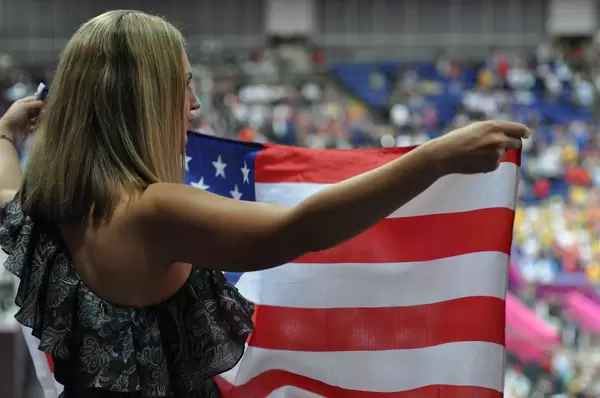 Junge Frau mit US-amerikanischer Flagge in Händen