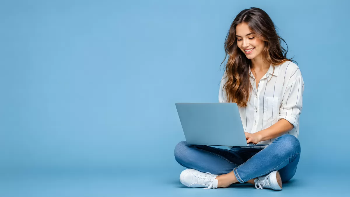 Junge Frau sitzt mit Laptop auf dem Boden