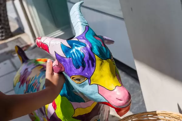 Junge Frau zieht die bunte Zeigen-Staute am Ohr