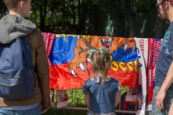 Junge Fußballfans schauen sich Flaggen und Schals an