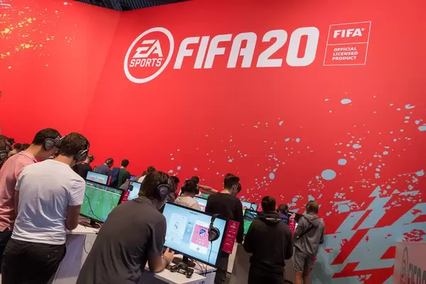 Junge Gamer spielen FIFA 20 von EA Sports an Spielstationen auf der Gamescom