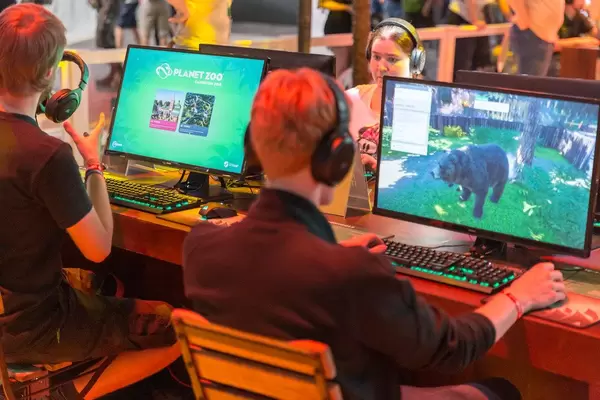 Junge Gamescombesucher spielen das Single Player - Simulationsspiel Planet Zoo am PC