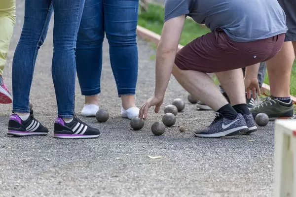 Junge Männer und Frauen spielen Boule
