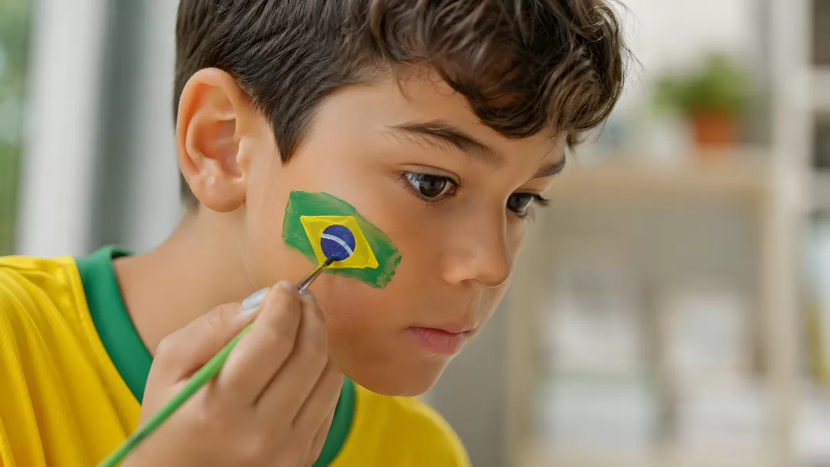 Junge mit Brasilien-Flagge auf der Wange geschminkt