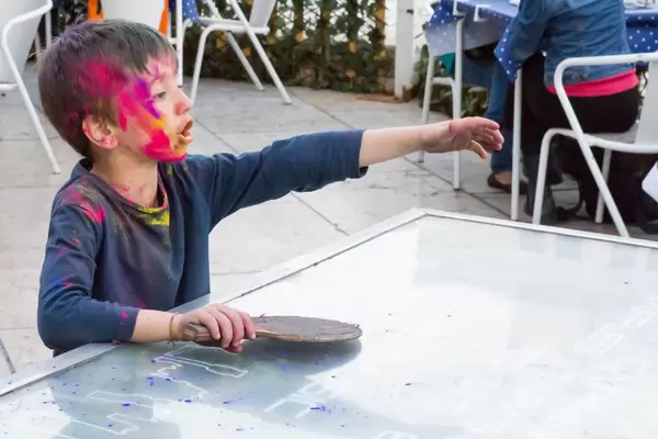 Junge mit Holi-Farbe spielt Tischtennis
