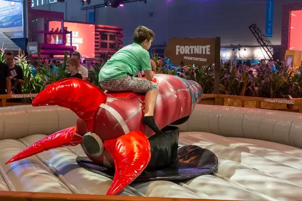 Junge reitet eine Rakete am Messestand von Fortnite auf der Gamescom