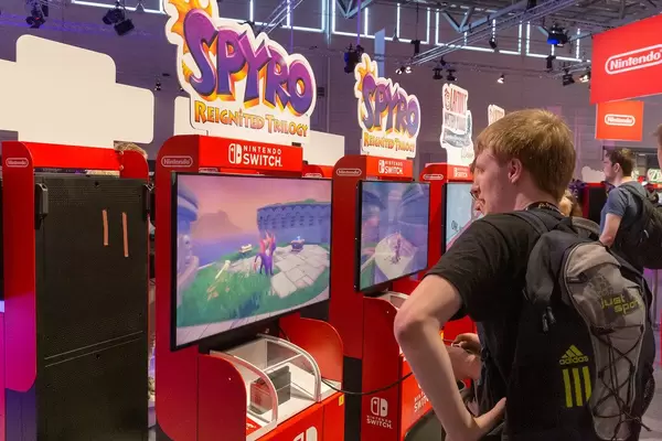 Junge Spielemesserbesucher der Gamescom spielen Spyro - Reignited Trilogy auf der Nintendo Switch