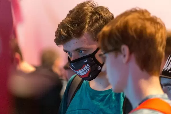 Junge trägt Mundschutz-Maske mit Gebissaufdruck, auf der Gamescom