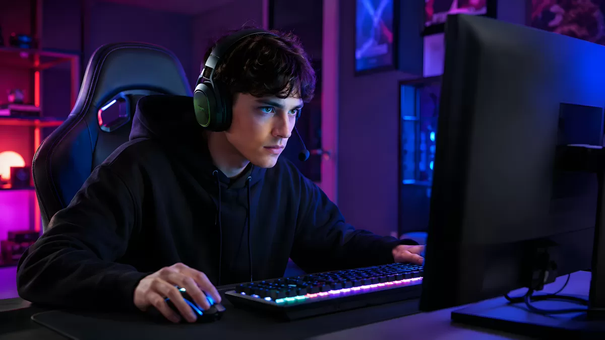 Junger Gamer mit Headset vor beleuchtetem PC-Setup