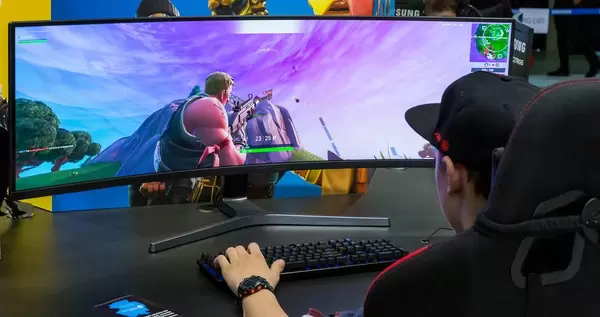 Junger IFA-Besucher zockt Fortnite auf einem ultraweit-Bildschirm von Panasonic