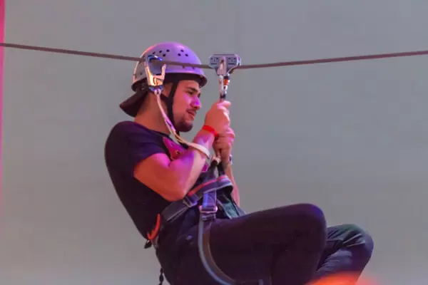 Junger Mann auf einer Seilrutsche