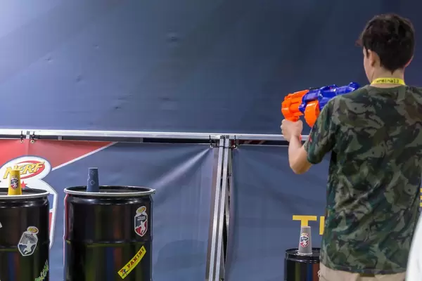 Junger Mann im Begriff mit einem Blaster mit Schaumstoffmunition zu schießen