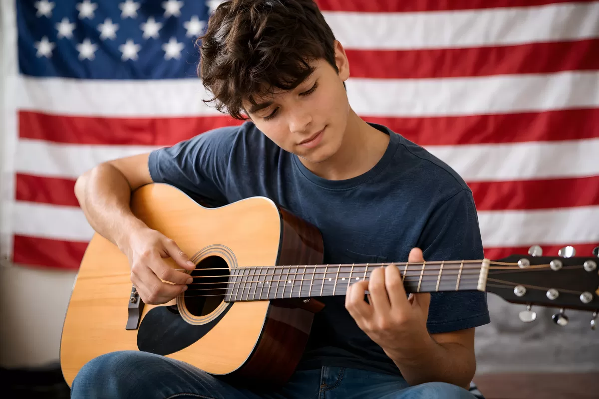 Junger US-Amerikaner spielt Gitarre vor Nationalflagge
