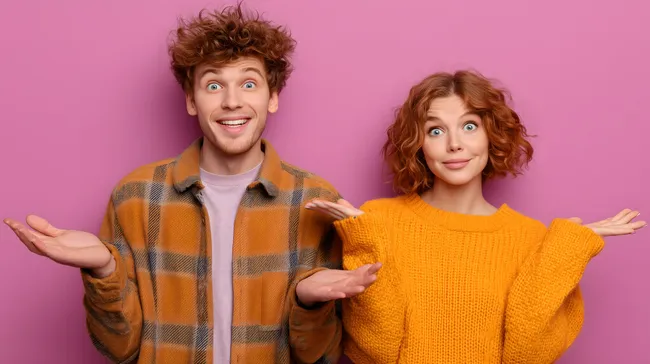 Junges Paar mit ausgebreiteten Armen vor rosa Wand