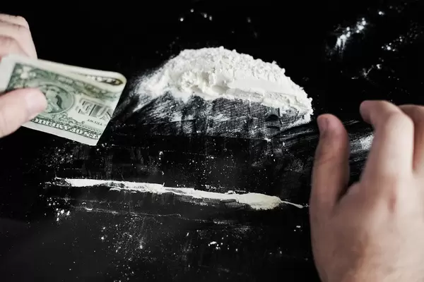 Junkie man making lines of cocaine white powder for snorting