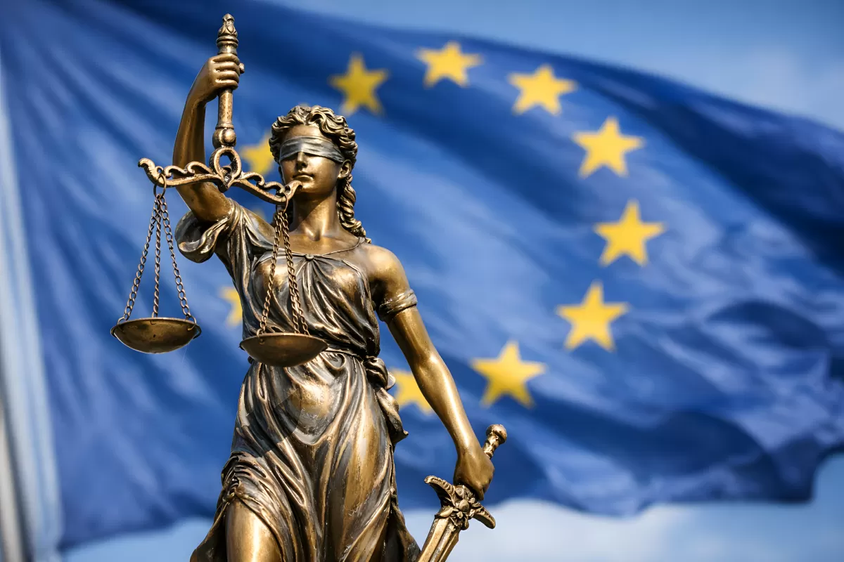 Justitia-Statue vor der Europäischen Union Flagge
