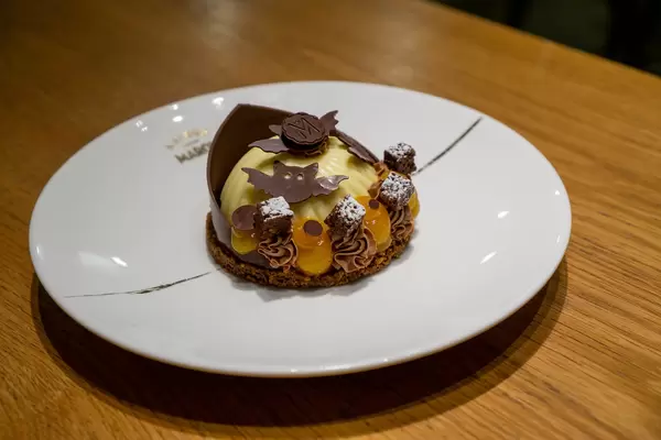 Käsekuchen mit Lebkuchen Boden, Kumquat Creme und Schokoladen Dekoration in Halloween Design
